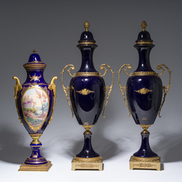 Three French gold layered blue ground gilt bronze mounted S&egrave;vres style vases and covers with gallant scenes, 20th C.