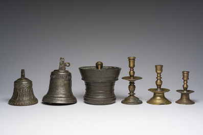 Two bells, a mortar and stamper, three candlesticks and an alms dish in bronze and brass, 17th/19th C.