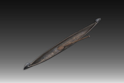 A large Indian wooden Kerala snake canoe with a curled stem and stern with accompanying paddle, 20th C.