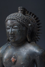 An Indian polished black marble sculpture of a Jina seated in dhyanasana on an ornate cushion, probably Gujarat, 15th C.