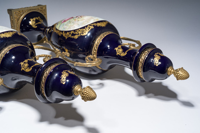 Three French gold layered blue ground gilt bronze mounted S&egrave;vres style vases and covers with gallant scenes, 20th C.