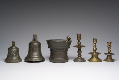 Two bells, a mortar and stamper, three candlesticks and an alms dish in bronze and brass, 17th/19th C.