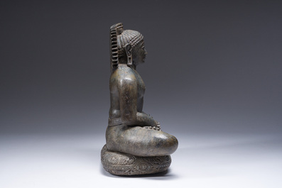 An Indian polished black marble sculpture of a Jina seated in dhyanasana on an ornate cushion, probably Gujarat, 15th C.