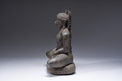 An Indian polished black marble sculpture of a Jina seated in dhyanasana on an ornate cushion, probably Gujarat, 15th C.