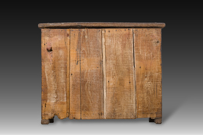 A carved oak one-door cupboard with the central panel carved with two heads, probably Germany, 16th C.