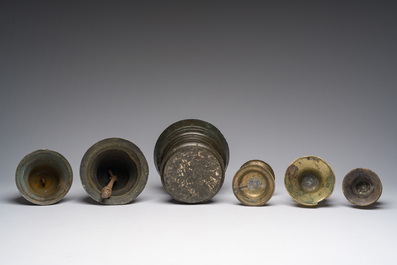 Two bells, a mortar and stamper, three candlesticks and an alms dish in bronze and brass, 17th/19th C.
