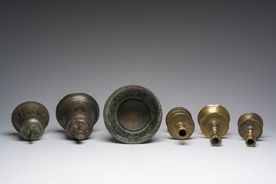 Two bells, a mortar and stamper, three candlesticks and an alms dish in bronze and brass, 17th/19th C.