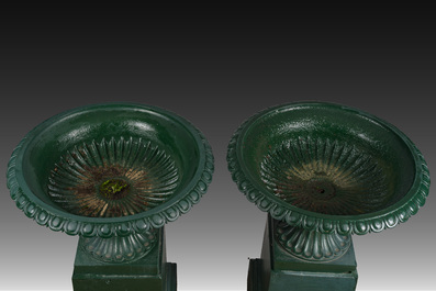 Een paar groengepatineerde gietijzeren tuinvazen op voet, 20ste eeuw