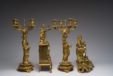 Two gilt bronze mantel clocks and a pair of four-light caryatid-shaped candlesticks, France and Germany, 19th/20th C.