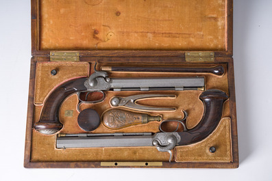 A French dueling box containing a pair of percussion pistols with damask barrels and engraved breechblocks, 19th C.