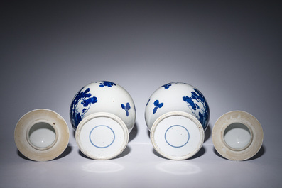 A pair of Chinese blue and white vases and covers with magpies among peonies, 19th C.