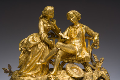 A French gilt bronze mantel clock crowned by a couple in love chatting on a bench, 19th C.