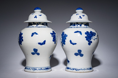 A pair of Chinese blue and white vases and covers with magpies among peonies, 19th C.