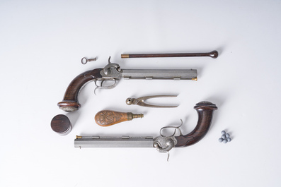 A French dueling box containing a pair of percussion pistols with damask barrels and engraved breechblocks, 19th C.