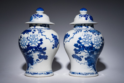 A pair of Chinese blue and white vases and covers with magpies among peonies, 19th C.