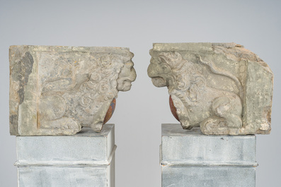 A pair of partly polychromed stone beam supports in the shape of lions holding coats of arms, probably Flanders, 16th/17th C.