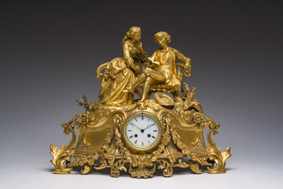 A French gilt bronze mantel clock crowned by a couple in love chatting on a bench, 19th C.