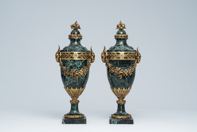 Een paar Franse neoclassicistische cassolettes in vert de mer marmer met ramskoppen en bloemenguirlandes in verguld brons, 19de/20ste eeuw