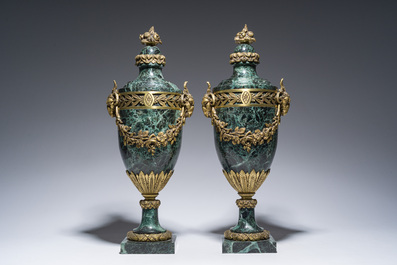 Een paar Franse neoclassicistische cassolettes in vert de mer marmer met ramskoppen en bloemenguirlandes in verguld brons, 19de/20ste eeuw