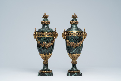 Een paar Franse neoclassicistische cassolettes in vert de mer marmer met ramskoppen en bloemenguirlandes in verguld brons, 19de/20ste eeuw