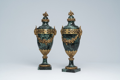 Een paar Franse neoclassicistische cassolettes in vert de mer marmer met ramskoppen en bloemenguirlandes in verguld brons, 19de/20ste eeuw