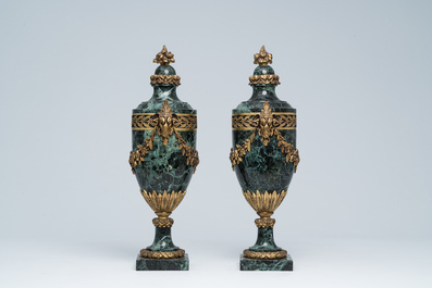 Een paar Franse neoclassicistische cassolettes in vert de mer marmer met ramskoppen en bloemenguirlandes in verguld brons, 19de/20ste eeuw