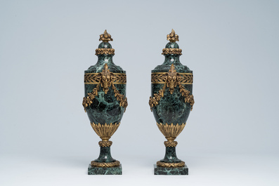 Een paar Franse neoclassicistische cassolettes in vert de mer marmer met ramskoppen en bloemenguirlandes in verguld brons, 19de/20ste eeuw