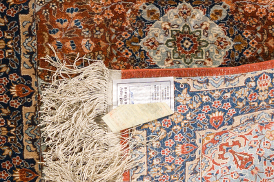 A Persian Qom (Qum/Ghom) silk rug and a Chinese silk Hereke style rug with floral design, 20th C.
