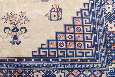 A Chinese Beijing rug with antiquities, floral design and stylized motifs, wool on cotton, 20th C.