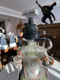 Een Chinese verguld bronzen sculptuur van een wachter met polychroom decor, 18de/19de eeuw