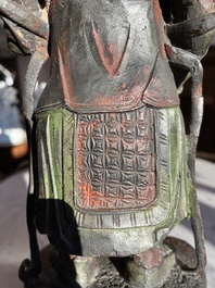 Een Chinese verguld bronzen sculptuur van een wachter met polychroom decor, 18de/19de eeuw