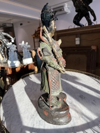 Een Chinese verguld bronzen sculptuur van een wachter met polychroom decor, 18de/19de eeuw