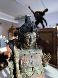 Een Chinese verguld bronzen sculptuur van een wachter met polychroom decor, 18de/19de eeuw