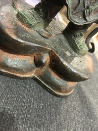 Een Chinese verguld bronzen sculptuur van een wachter met polychroom decor, 18de/19de eeuw