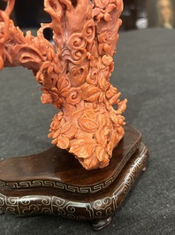 A Chinese red coral group of parrots among blossoming branches on a silver-inlaid wooden stand, 19th/20th C.