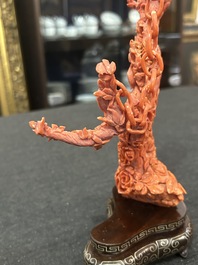 A Chinese red coral group of parrots among blossoming branches on a silver-inlaid wooden stand, 19th/20th C.