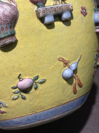 An exceptional pair of Chinese famille rose yellow sgraffito-ground bottle vases with applied design of antiquities, 19th C.