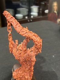 A Chinese red coral group of parrots among blossoming branches on a silver-inlaid wooden stand, 19th/20th C.