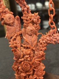 A Chinese red coral group of parrots among blossoming branches on a silver-inlaid wooden stand, 19th/20th C.