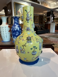 An exceptional pair of Chinese famille rose yellow sgraffito-ground bottle vases with applied design of antiquities, 19th C.