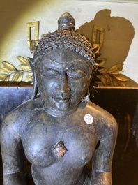 An Indian polished black marble sculpture of a Jina seated in dhyanasana on an ornate cushion, probably Gujarat, 15th C.