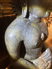 An Indian polished black marble sculpture of a Jina seated in dhyanasana on an ornate cushion, probably Gujarat, 15th C.