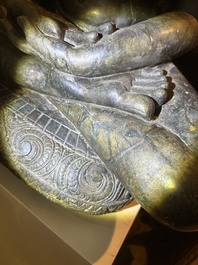 An Indian polished black marble sculpture of a Jina seated in dhyanasana on an ornate cushion, probably Gujarat, 15th C.