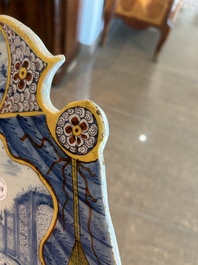 Een polychrome Delftse plaquette met een fontein in theatrale gordijnlijst, 18de eeuw