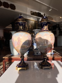 Een paar grote S&egrave;vres porseleinen vazen met allegorie&euml;n van 'De oogst' en 'De visvangst' op verguld bronzen monturen, Frankrijk, 19de eeuw