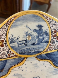 Een polychrome Delftse plaquette met een fontein in theatrale gordijnlijst, 18de eeuw
