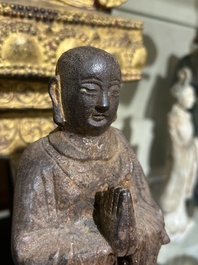 A Chinese cast iron sculpture of a Luohan, probably Ming
