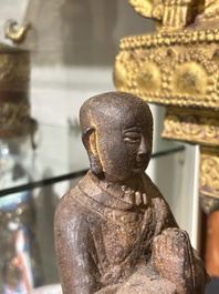 A Chinese cast iron sculpture of a Luohan, probably Ming