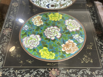 A Chinese rectangular lacquered wooden table with three cloisonn&eacute; plaques, 20th C.
