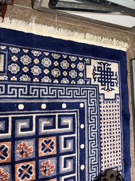 A Chinese Beijing rug with antiquities, floral design and stylized motifs, wool on cotton, 20th C.